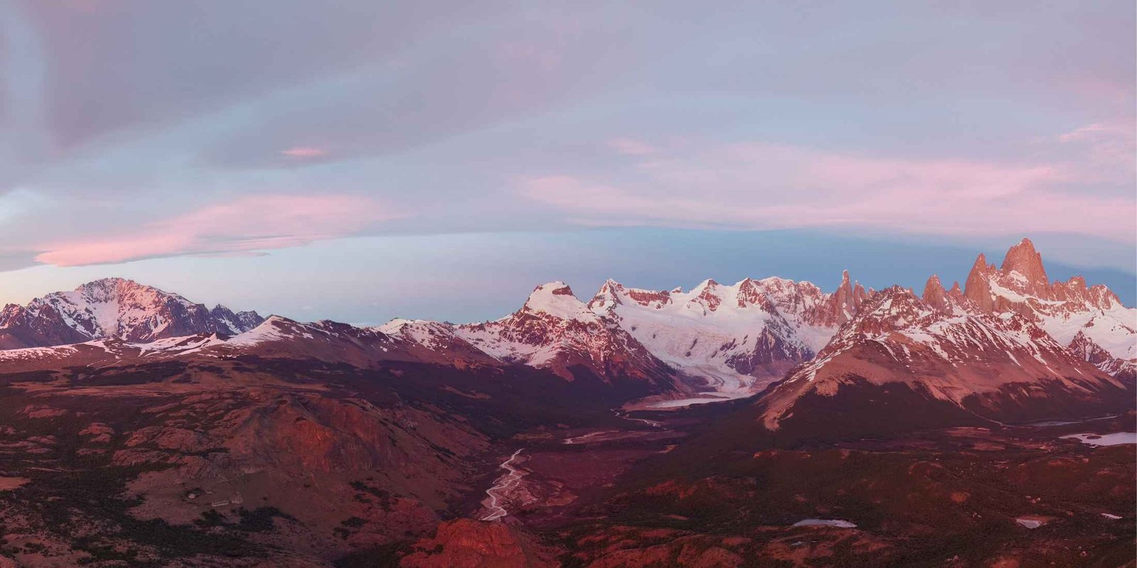 Cerro Fitz Roy and the surrounding snow-covered mountains near El Chaltén, Patagonia, in pink light.